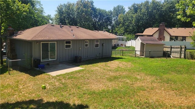 rear view of house featuring a lawn, a patio, and central AC