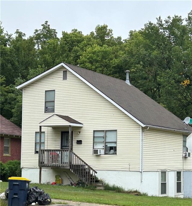 view of front facade featuring a front yard and cooling unit