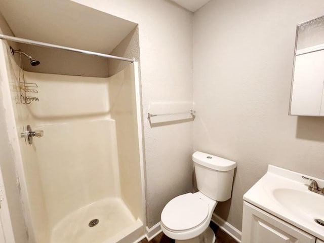 bathroom featuring a shower, vanity, and toilet