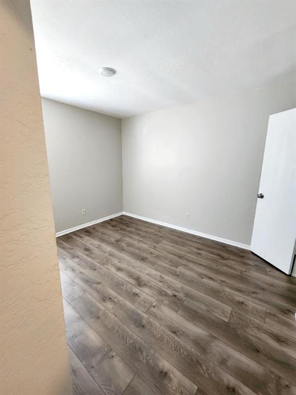 spare room with dark hardwood / wood-style flooring