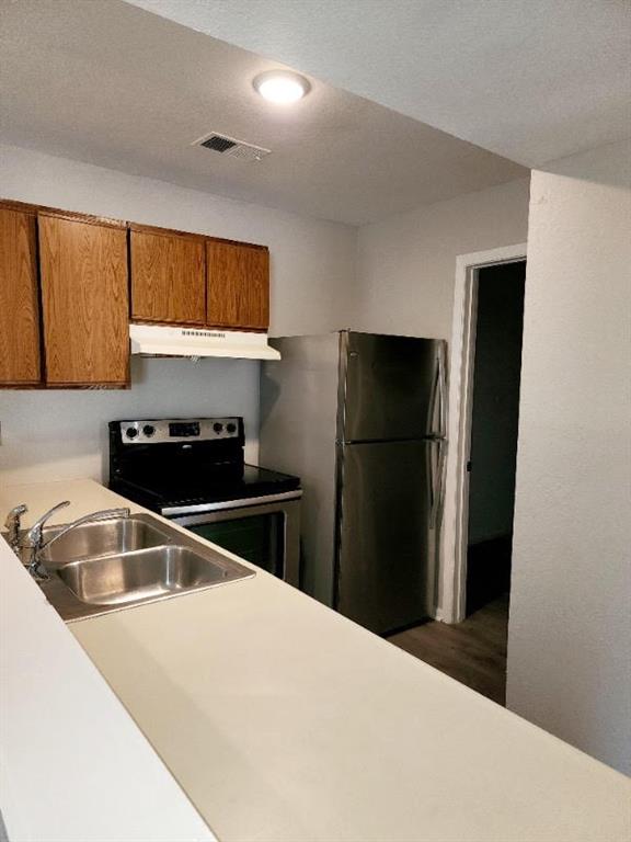 kitchen featuring appliances with stainless steel finishes, a textured ceiling, and sink