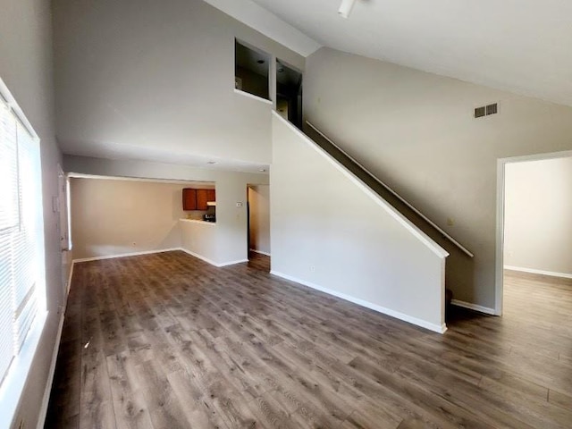 unfurnished living room with hardwood / wood-style floors, high vaulted ceiling, and a healthy amount of sunlight