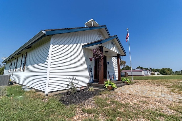 view of front facade with a garage, a front yard, and cooling unit