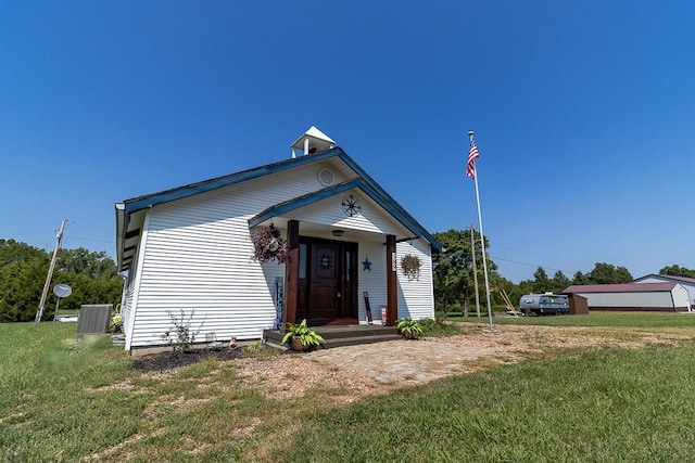 view of front facade featuring a front yard and central AC unit