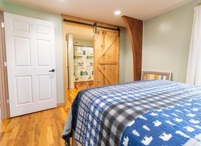 bedroom featuring light hardwood / wood-style flooring and a barn door