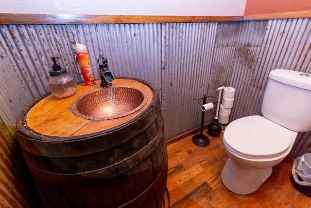 bathroom with toilet and wood-type flooring