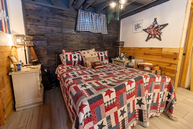 bedroom featuring wood-type flooring and wooden walls