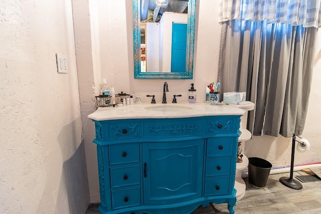 bathroom featuring hardwood / wood-style floors, toilet, and vanity