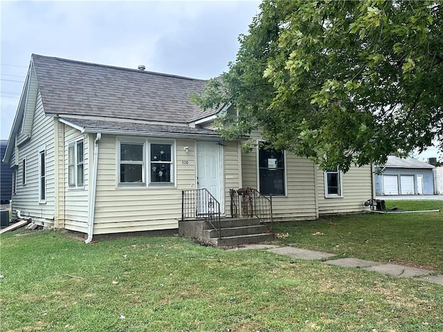 bungalow-style home with central air condition unit and a front lawn