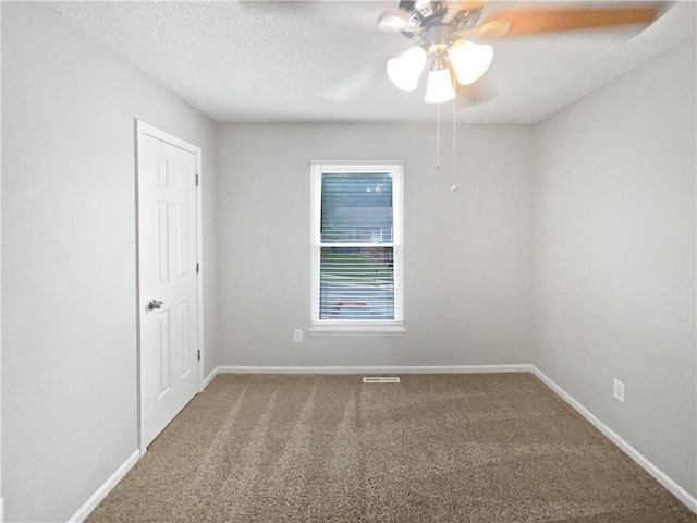 carpeted spare room with ceiling fan and a textured ceiling