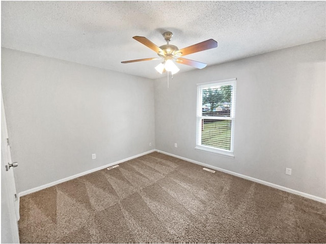 carpeted spare room with a textured ceiling and ceiling fan