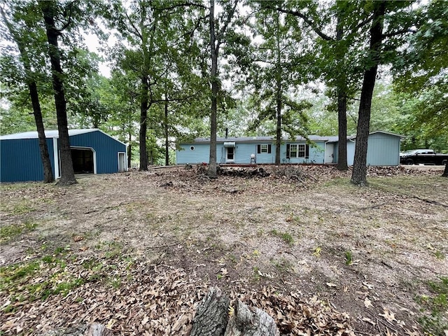 view of yard featuring a garage and an outbuilding