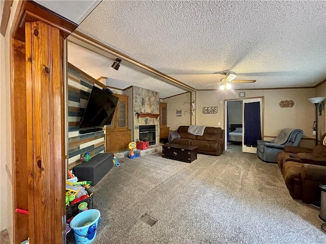 living room with ceiling fan, carpet flooring, a fireplace, and a textured ceiling