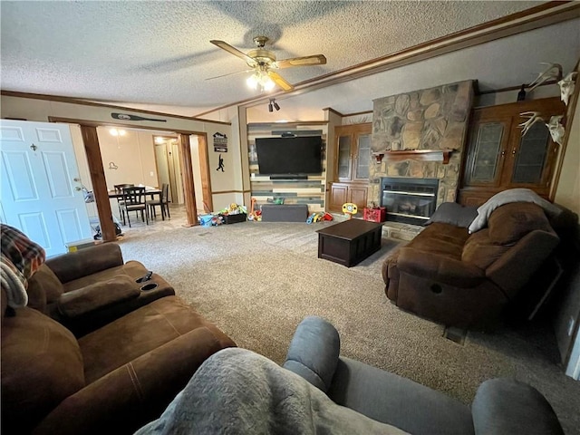 carpeted living room with a textured ceiling, a stone fireplace, ornamental molding, and ceiling fan