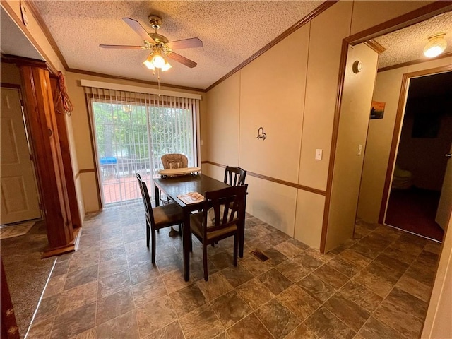 dining room featuring dark tile patterned flooring, ceiling fan, and a textured ceiling