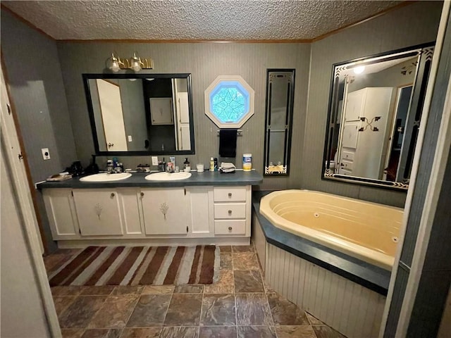 bathroom with a textured ceiling, a tub, dual vanity, and tile patterned flooring