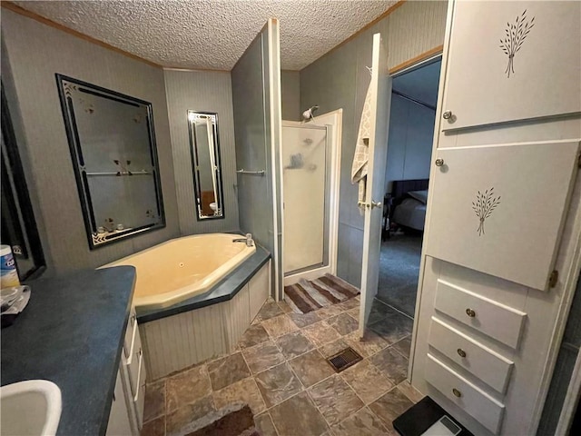 bathroom with vanity, a textured ceiling, separate shower and tub, and tile patterned flooring