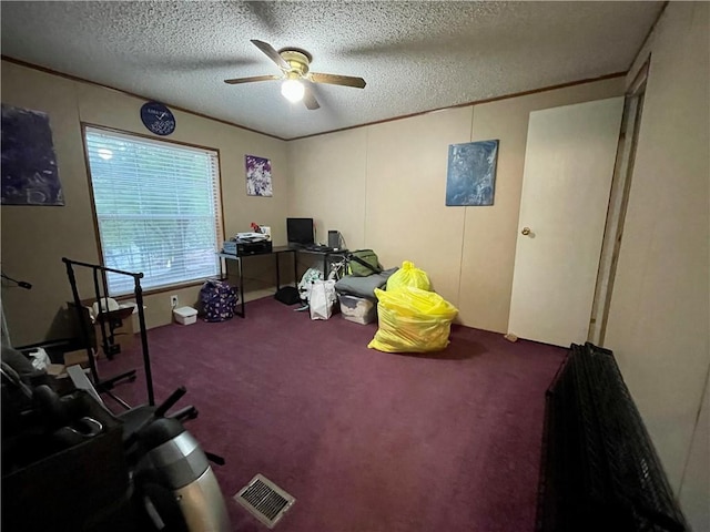 misc room with a textured ceiling, carpet, and ceiling fan