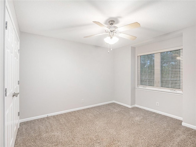 spare room featuring carpet floors, baseboards, and a ceiling fan