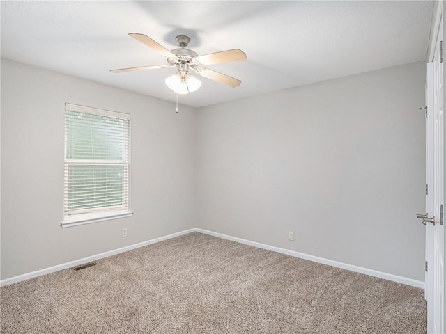 unfurnished room with a ceiling fan, carpet, visible vents, and baseboards