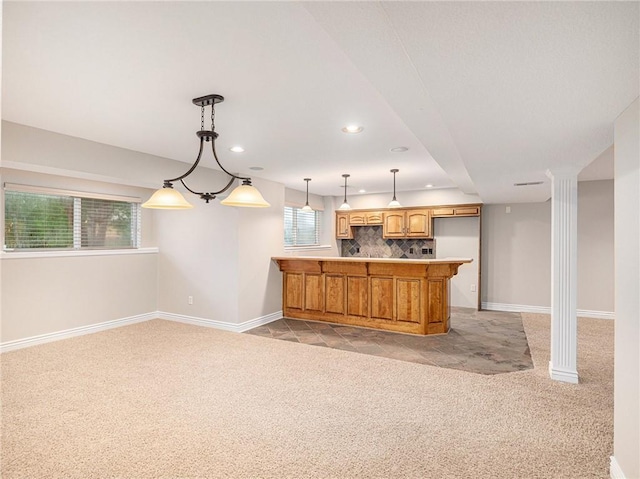 kitchen featuring baseboards, a peninsula, decorative backsplash, and light colored carpet