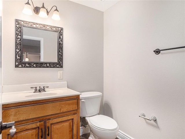 bathroom with toilet, vanity, and baseboards