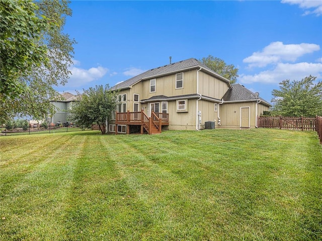 back of house featuring a fenced backyard, a lawn, a wooden deck, and central AC unit