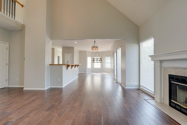 unfurnished living room with a fireplace, baseboards, and wood finished floors