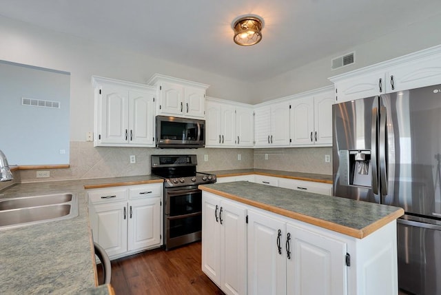 kitchen with white cabinets, visible vents, stainless steel appliances, and a sink