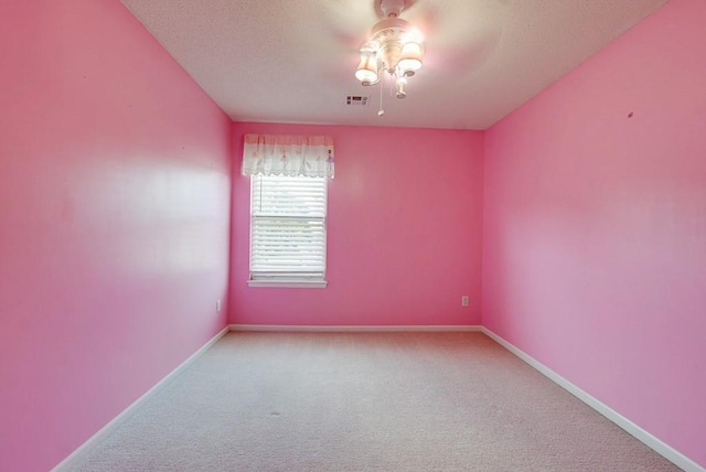 empty room with carpet, visible vents, baseboards, and ceiling fan