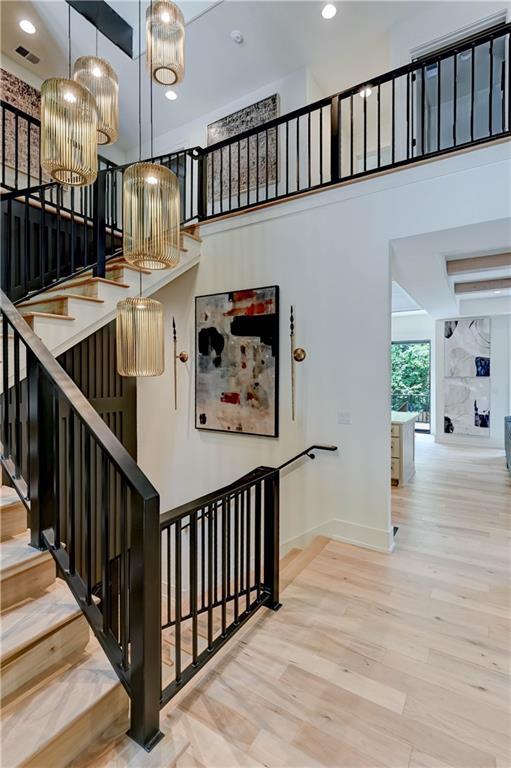2207 W 71st St, Prairie Village, KS 66208 - stairs featuring baseboards, wood finished floors, recessed lighting, a towering ceiling, and a chandelier