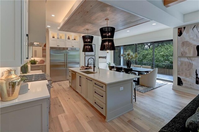 2207 W 71st St, Prairie Village, KS 66208 - kitchen with a sink, stainless steel appliances, light wood-type flooring, light countertops, and white cabinetry