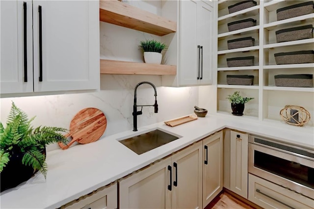 2207 W 71st St, Prairie Village, KS 66208 - kitchen with open shelves, a sink, light countertops, and decorative backsplash