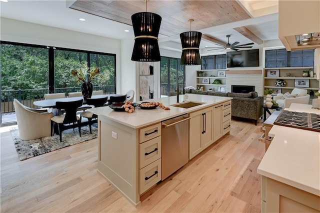 2207 W 71st St, Prairie Village, KS 66208 - kitchen featuring a sink, stainless steel dishwasher, ceiling fan, light wood finished floors, and a fireplace