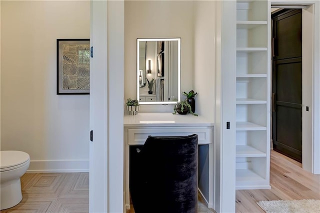 2207 W 71st St, Prairie Village, KS 66208 - bathroom featuring toilet, vanity, baseboards, and wood finished floors