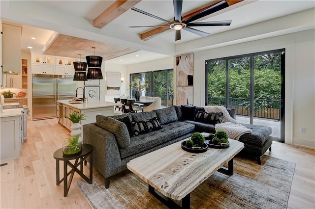 2207 W 71st St, Prairie Village, KS 66208 - living room with beam ceiling, light wood-type flooring, a ceiling fan, recessed lighting, and a chandelier