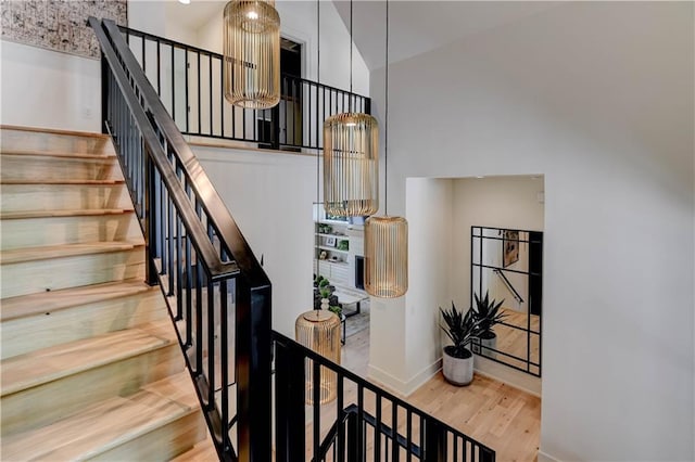 2207 W 71st St, Prairie Village, KS 66208 - stairs with wood finished floors, a towering ceiling, and baseboards
