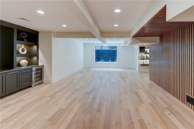 2207 W 71st St, Prairie Village, KS 66208 - unfurnished living room featuring wine cooler, light wood finished floors, beamed ceiling, recessed lighting, and baseboards