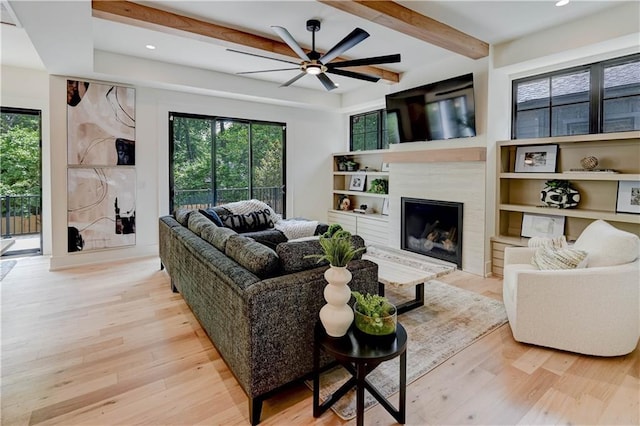 2207 W 71st St, Prairie Village, KS 66208 - living room featuring wood finished floors, plenty of natural light, ceiling fan, a fireplace, and beam ceiling