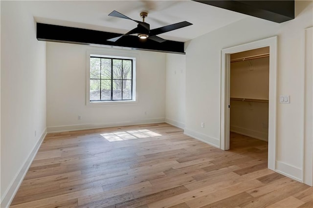 2207 W 71st St, Prairie Village, KS 66208 - unfurnished bedroom featuring a walk in closet, light wood-type flooring, baseboards, and a closet