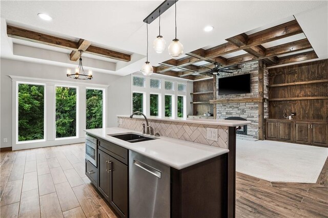 kitchen with coffered ceiling, pendant lighting, appliances with stainless steel finishes, sink, and light wood-type flooring