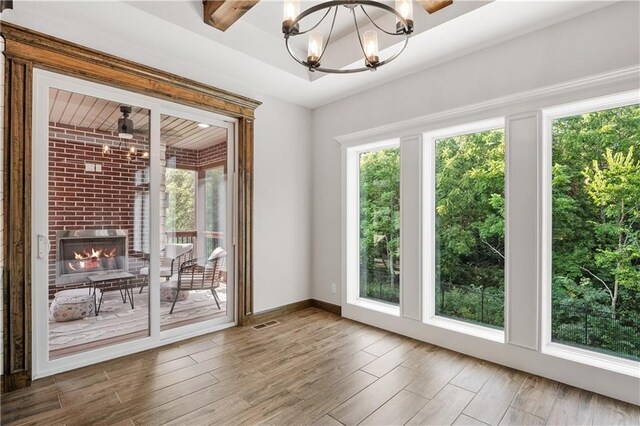 entryway featuring hardwood / wood-style floors, a fireplace, plenty of natural light, and an inviting chandelier