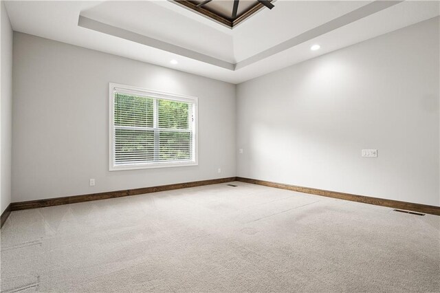 unfurnished room with a tray ceiling and carpet