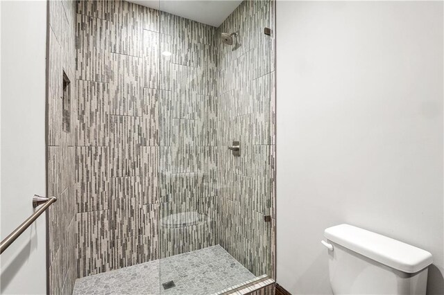 bathroom with toilet and a tile shower