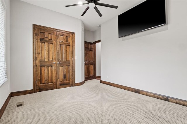 unfurnished bedroom featuring ceiling fan and carpet