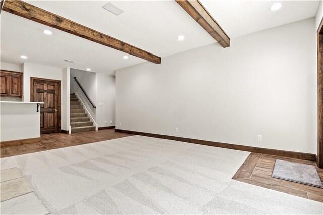 unfurnished living room with carpet and beam ceiling