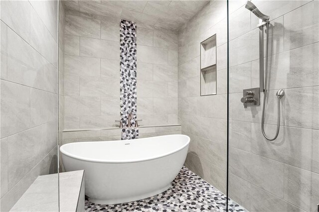 bathroom featuring tile walls and separate shower and tub