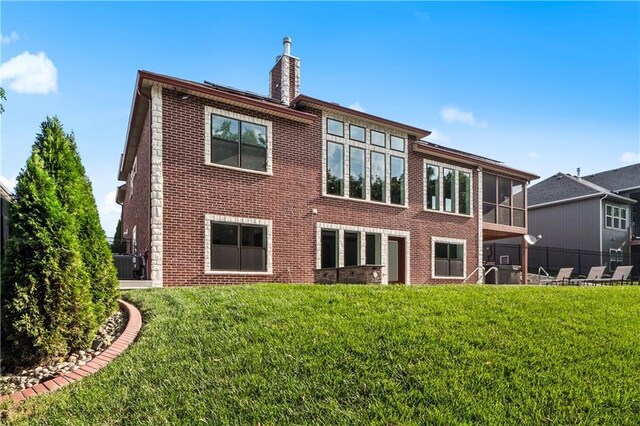 back of property featuring a yard and central AC