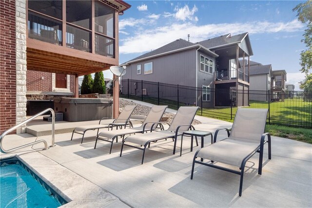 view of patio featuring a balcony and a hot tub