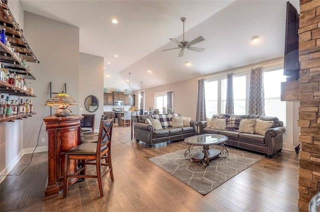 living room with ceiling fan, plenty of natural light, dark wood-type flooring, and high vaulted ceiling